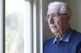 Older man looking out of window