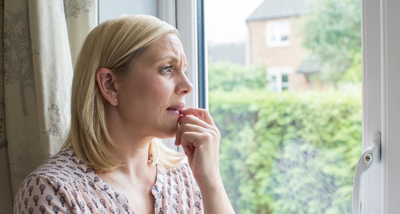 Concerned woman looking out of window